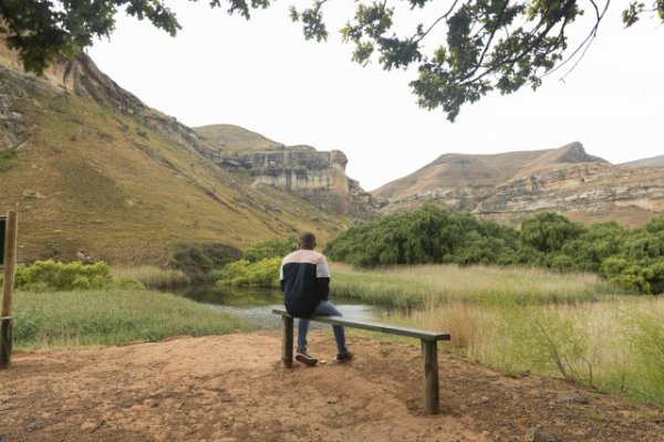 Black man sitting watching the mountains
