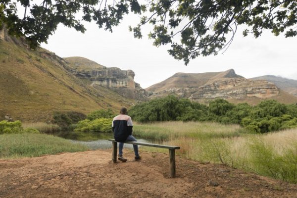 Black man sitting watching the mountains