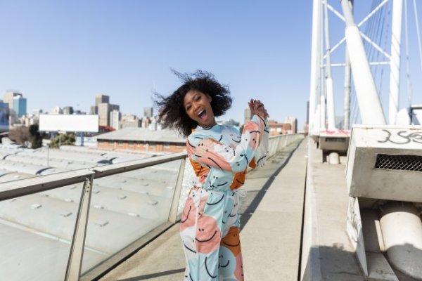 Black woman with curly hair jumping for joy