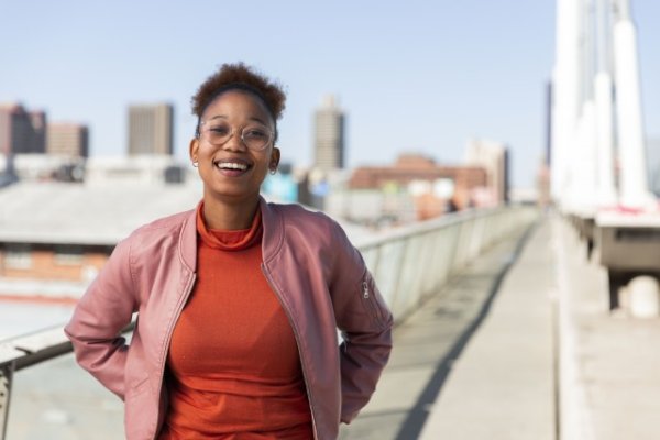 Black woman on Nelson Mandela bridge grinning with glasses
