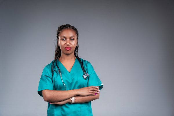 African female doctor wear green lab coat and stethoscope looking at camera.