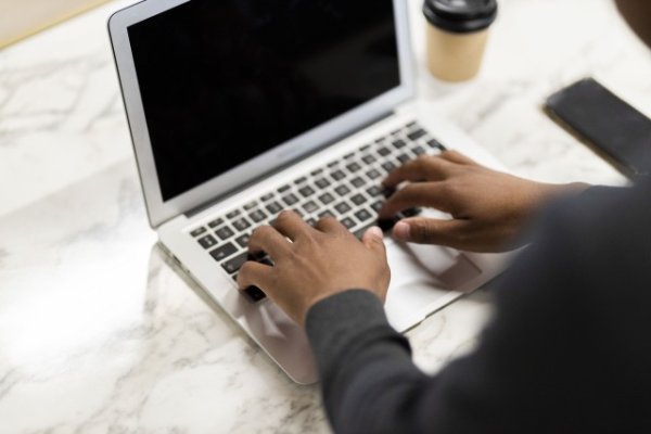Black hands working on his laptop