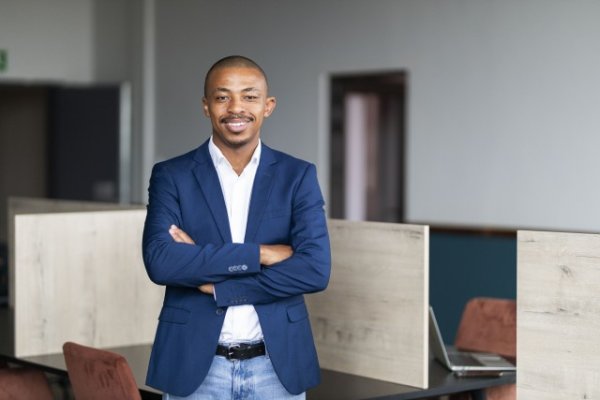Black business man smiling from his desk at the office