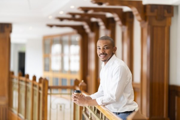 Black business man at work holding coffee