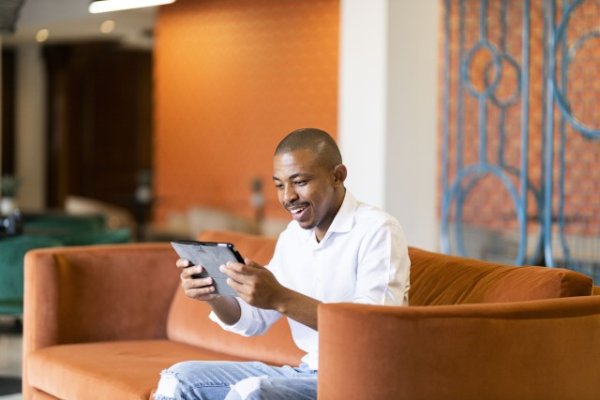 Black business man looking at his tablet and smiling