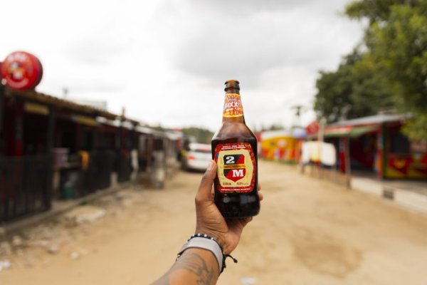 Black hand holding Mozambique beer.