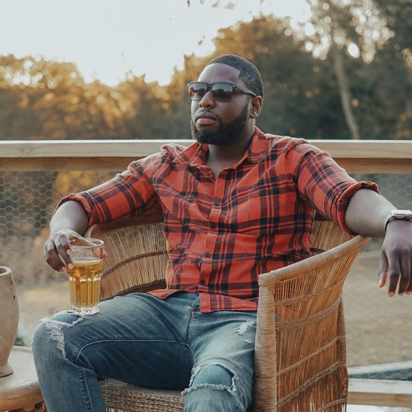 Black man sitting on a chair enjoying a drink