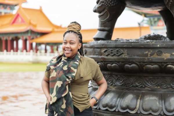 Black woman smiling at a Chinese tourist location