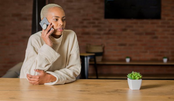 Black woman with blonde hair talking on the phone