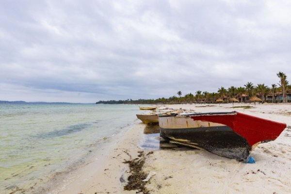 Boats near a lagoon of water on a gloomy day.