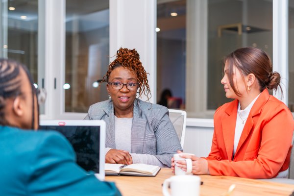Candidate speaking to mature African black woman at an office for a job interview.