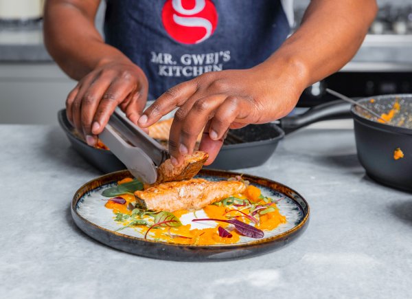 Chef serving grilled salmon on a plate