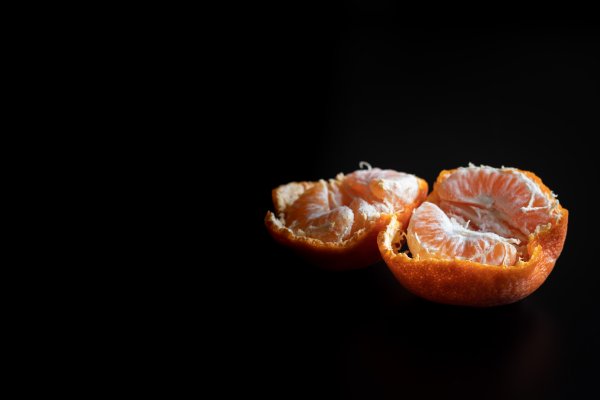 Fresh pealed mandarin / clementine on a black table