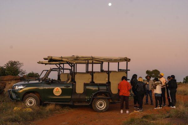 Friends on a game drive with the moon.