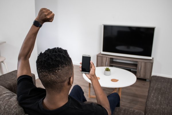 On the phone cheering from couch