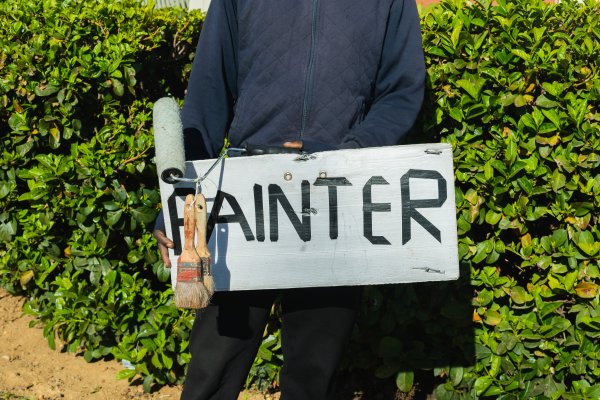Jobless man holding a painter sign.