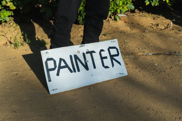 Jobless man holding a painter sign by his feet