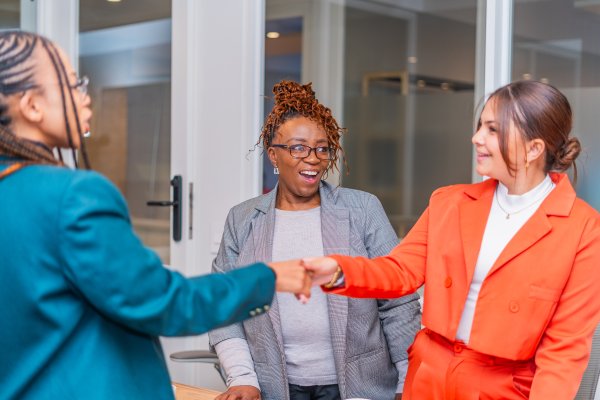 Mature woman smiles looking at client after a deal. Business women with handshake, lawyer and client with deal, contract and partnership.