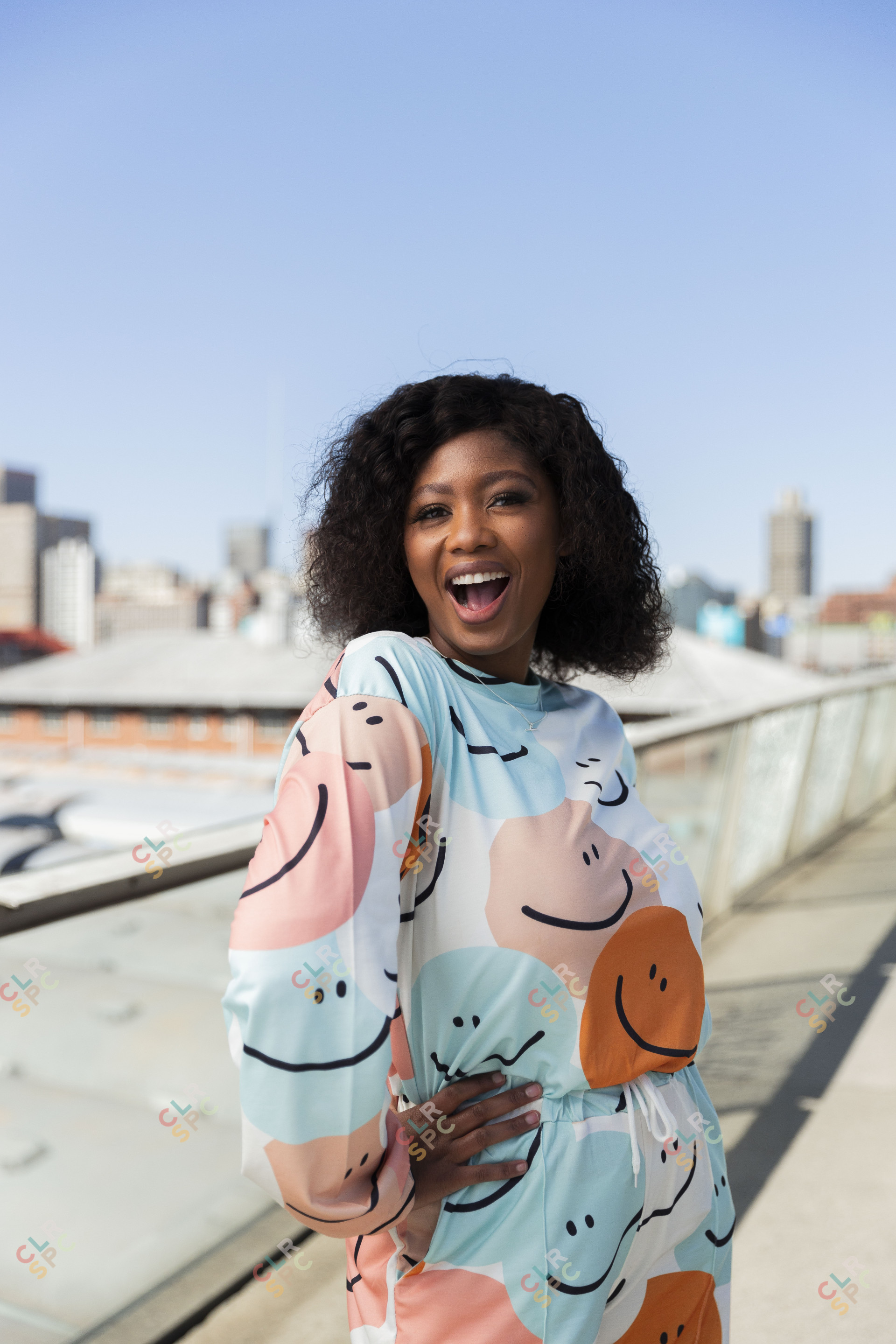 Black woman on Nelson Mandela bridge smiling with colourful clothing