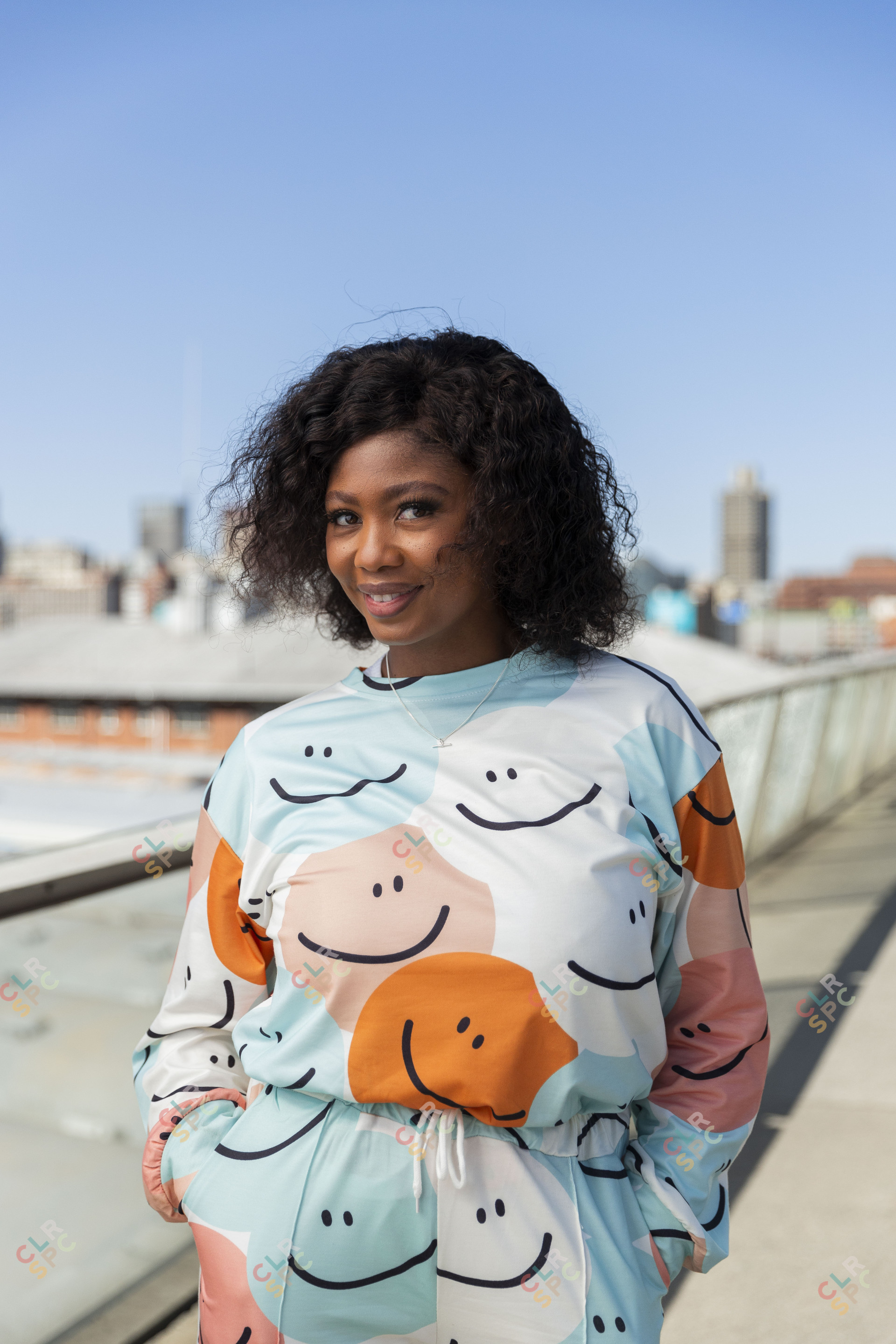 Black woman on Nelson Mandela bridge smiling with colourful clothing