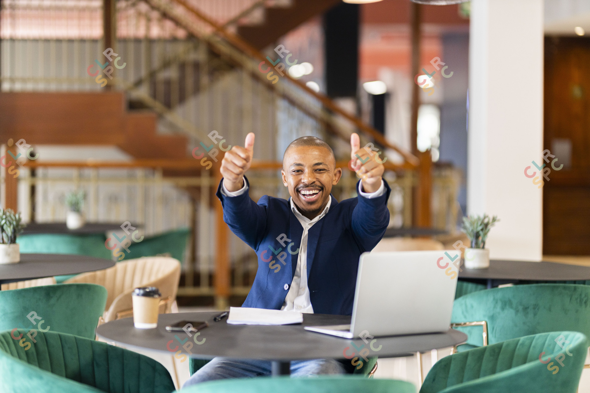 Black business man at work holding thumbs up