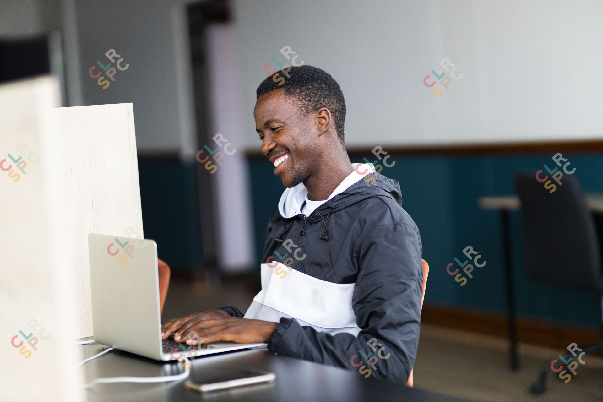 Black man celebrating looking at his laptop with a grin