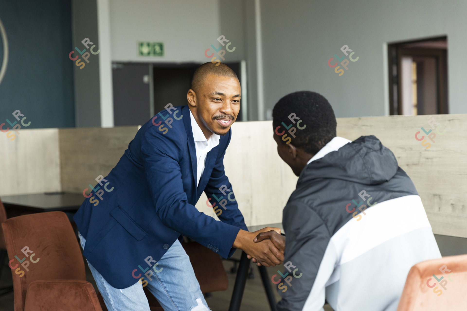 Black business man wearing a suit and shaking hands with a client