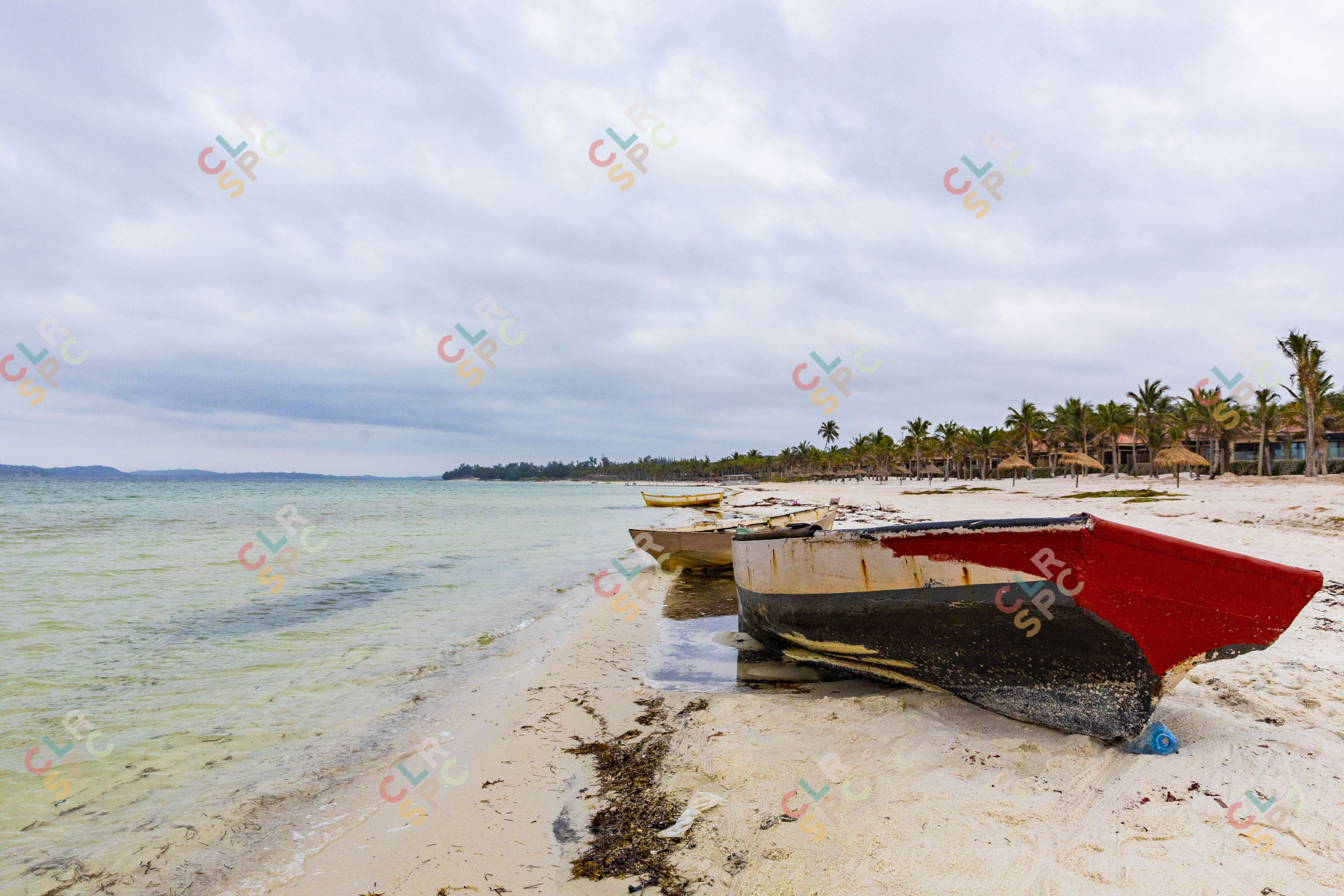 Boats near a lagoon of water on a gloomy day.