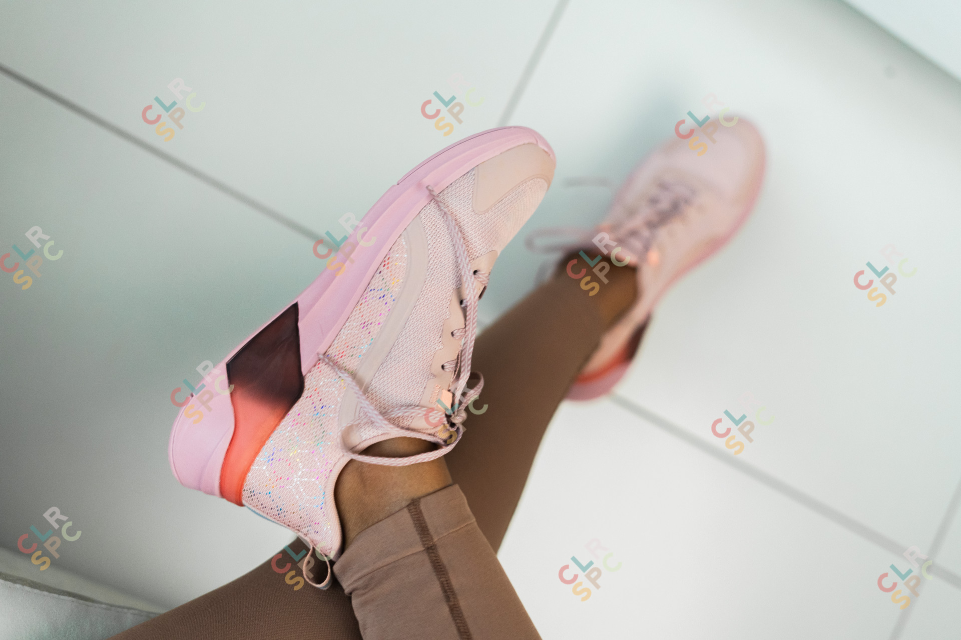 Pink running shoes worn by a black woman.