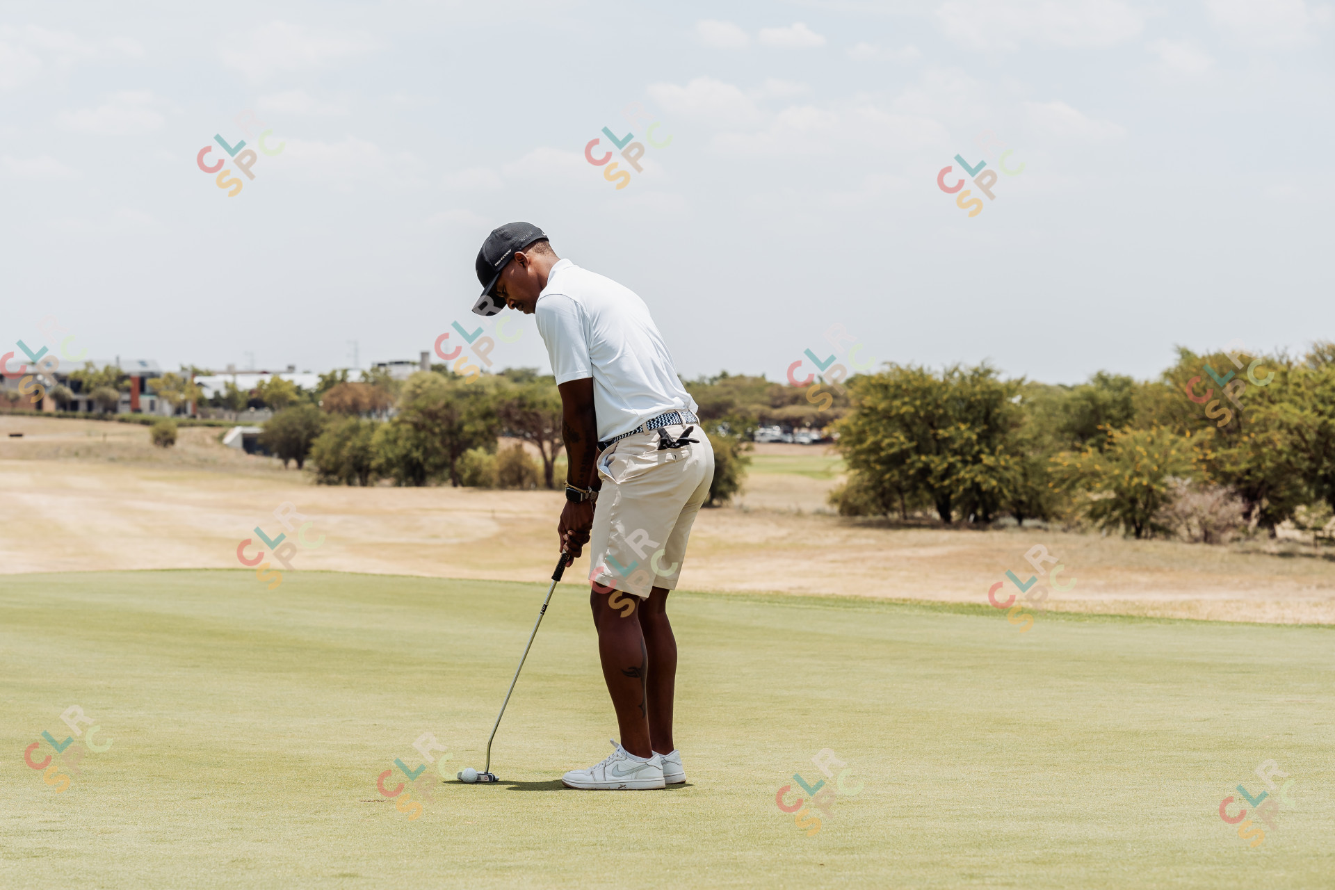 Black male golfer putting on the green