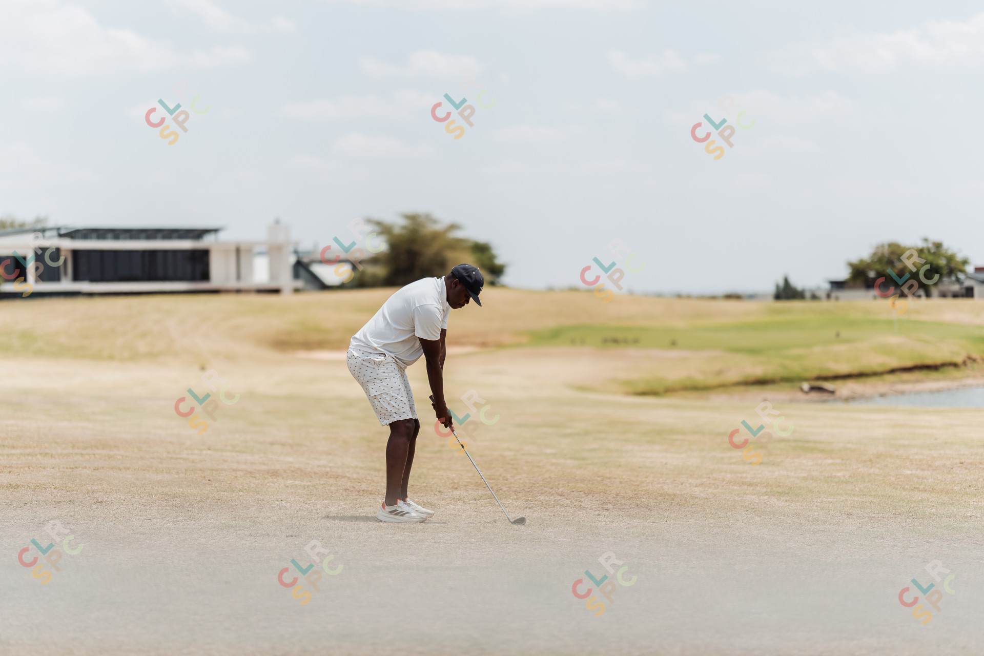 Black male golfer aiming at the green for a perfect shot
