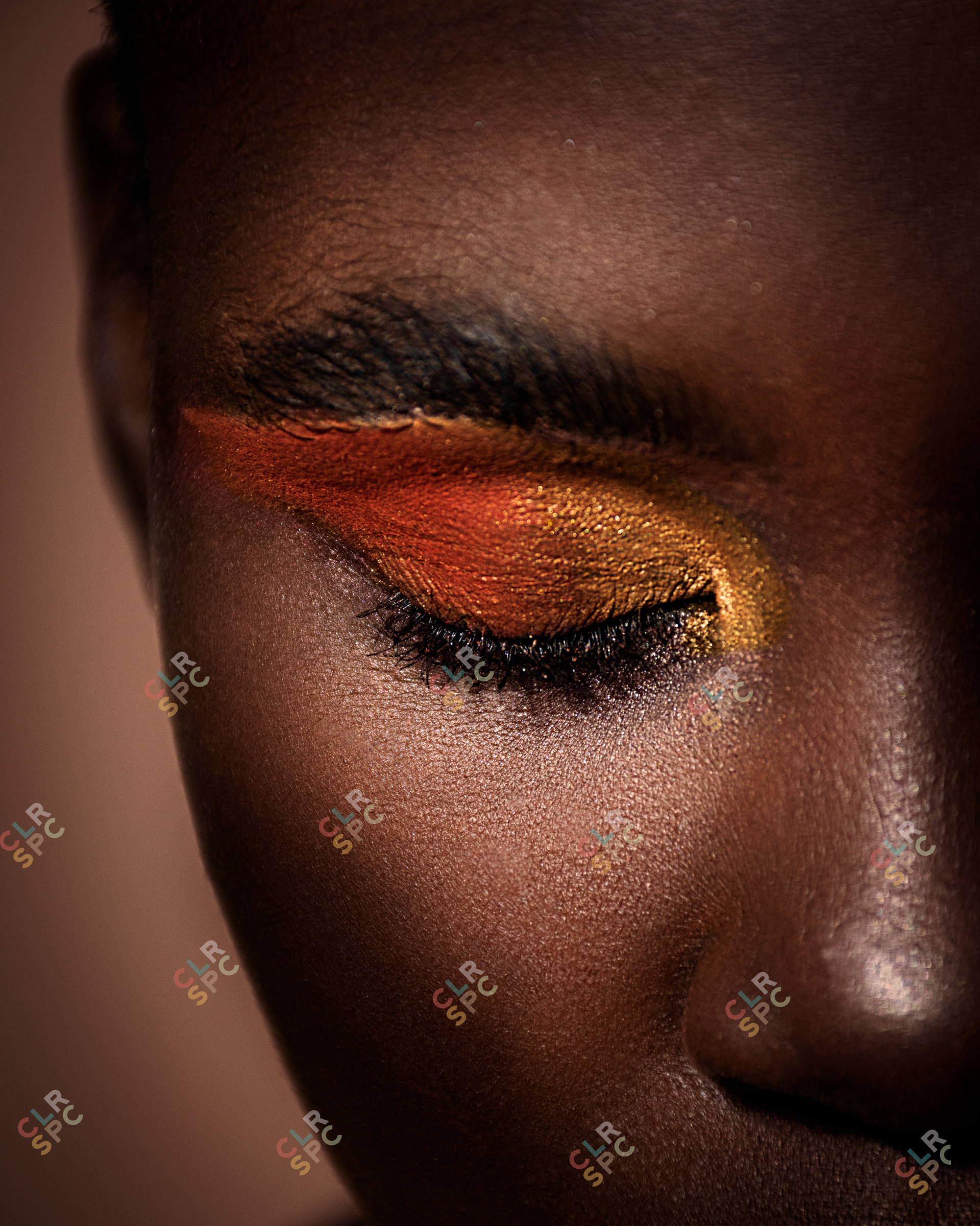 Portrait of an black African model with a dark melanin skin with yellow and orange eye make up on