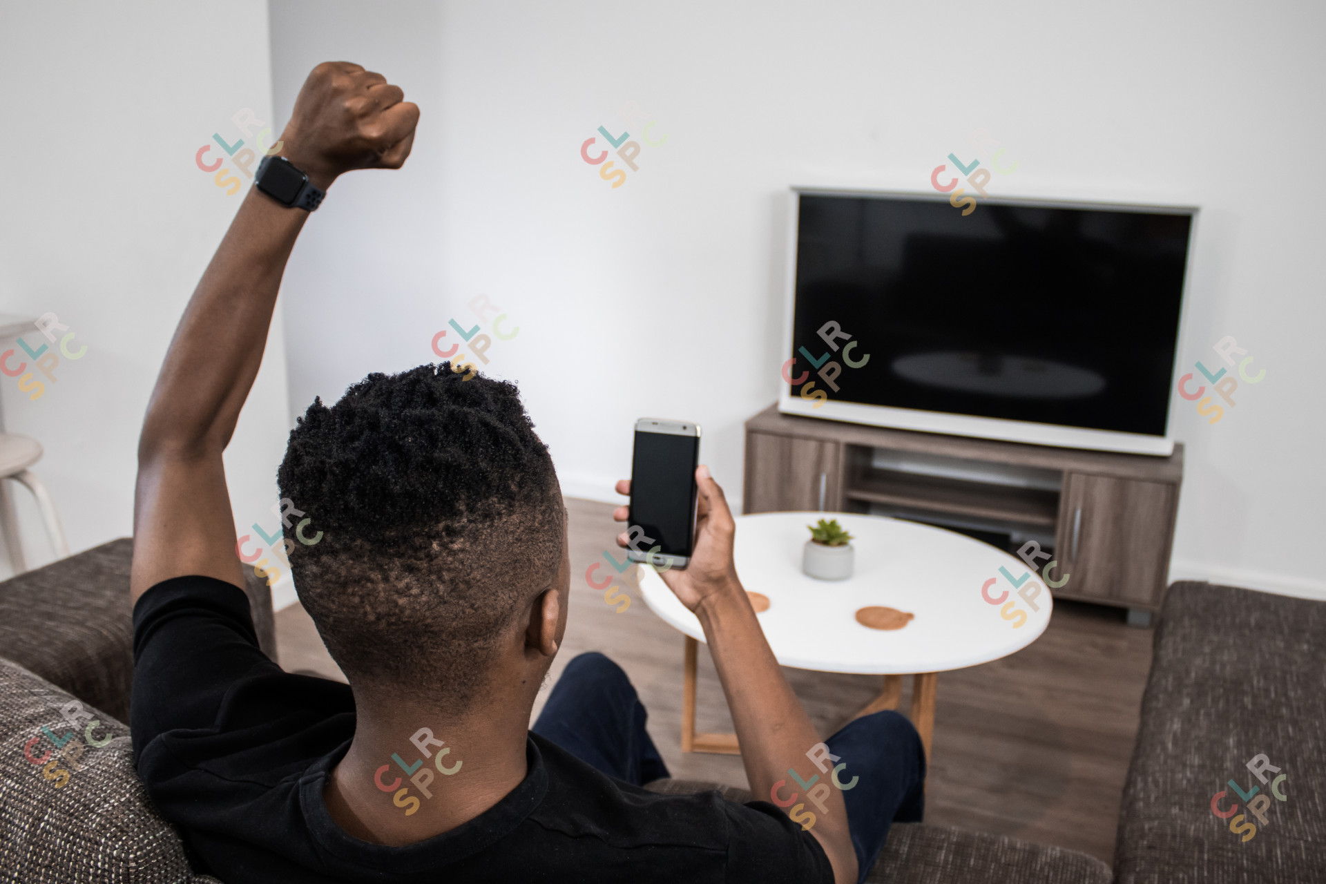 On the phone cheering from couch