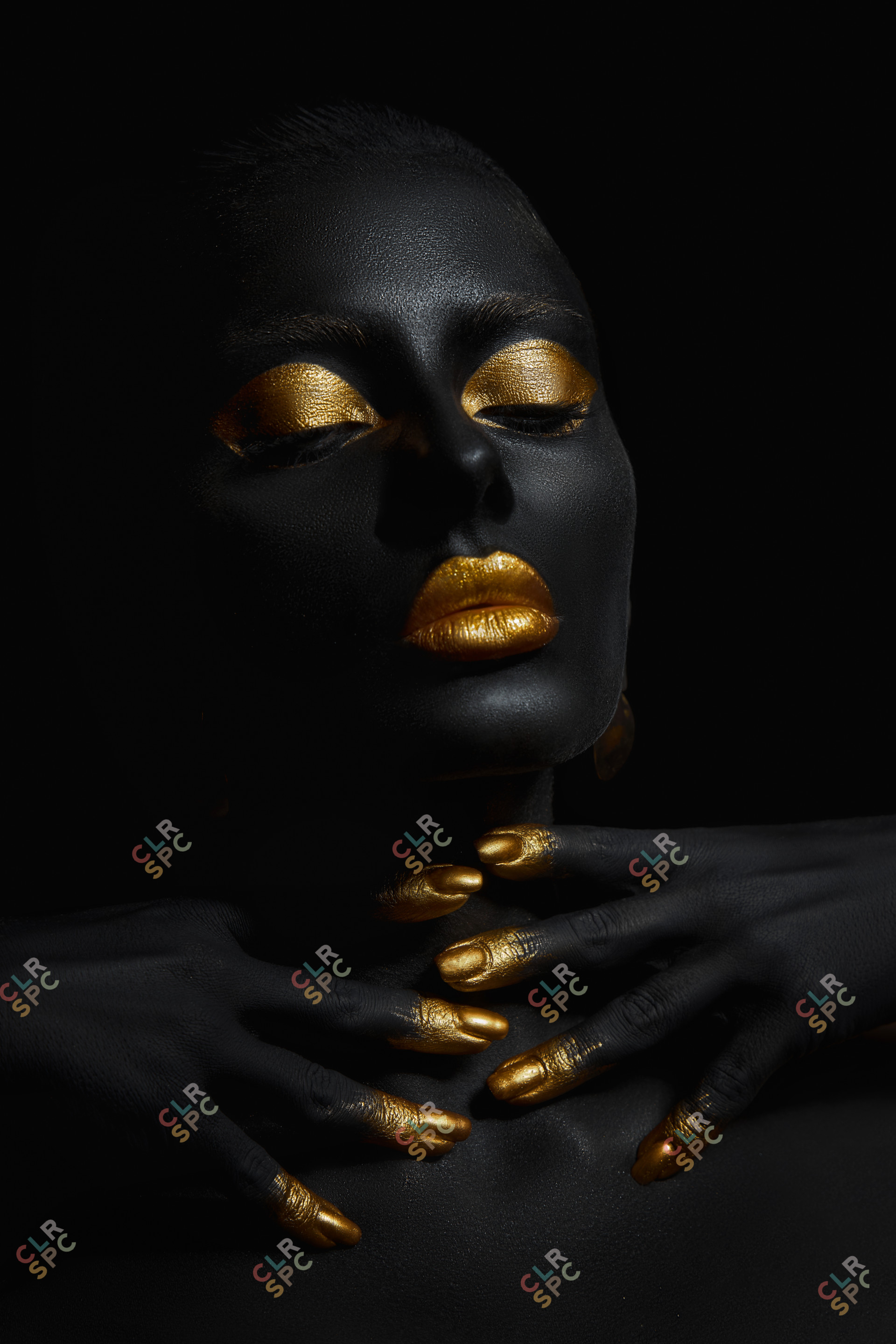 Beauty woman painted in black skin color body art, gold makeup l