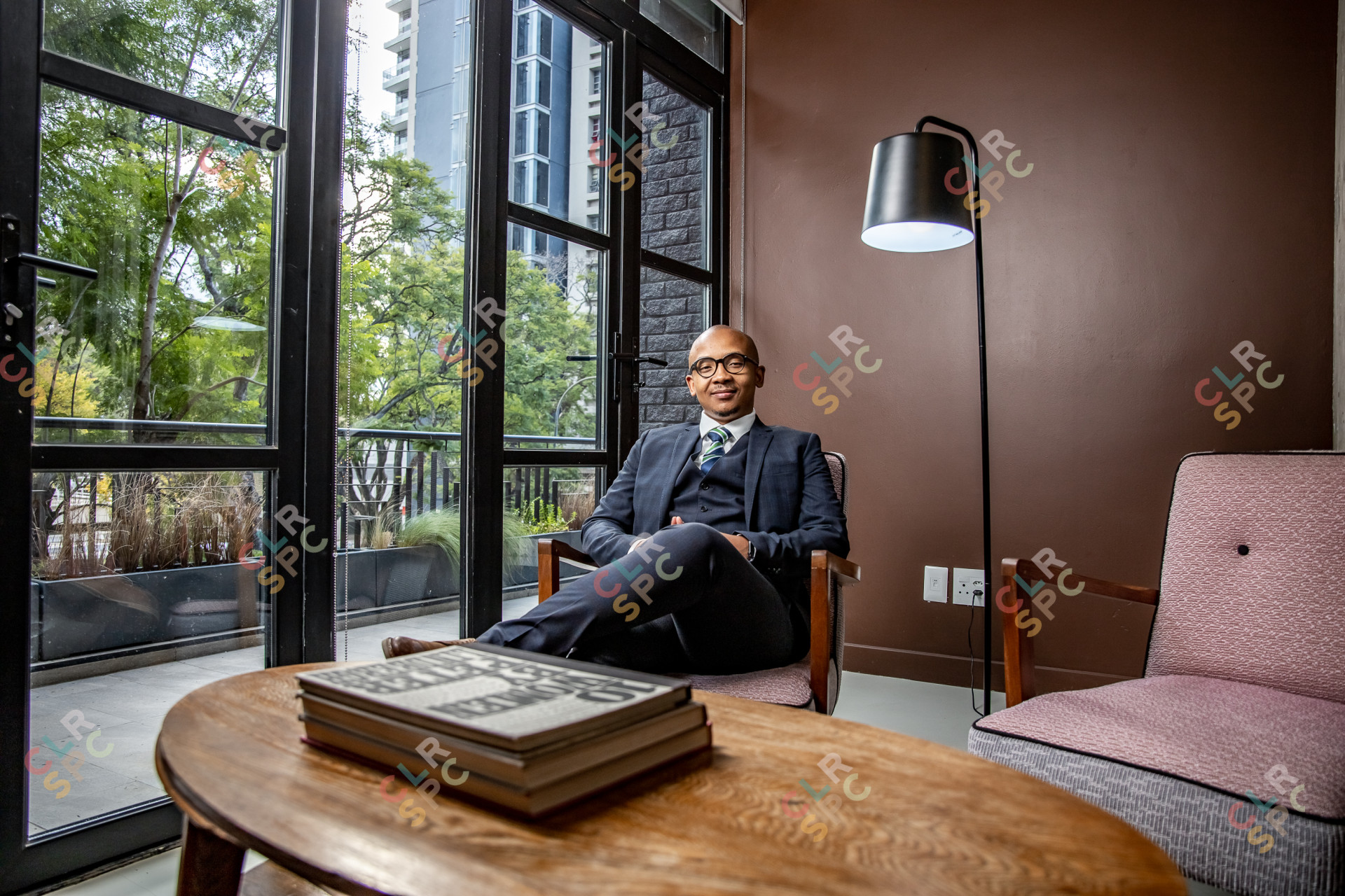 black businessman sitting on a chair in his office with books infront of him