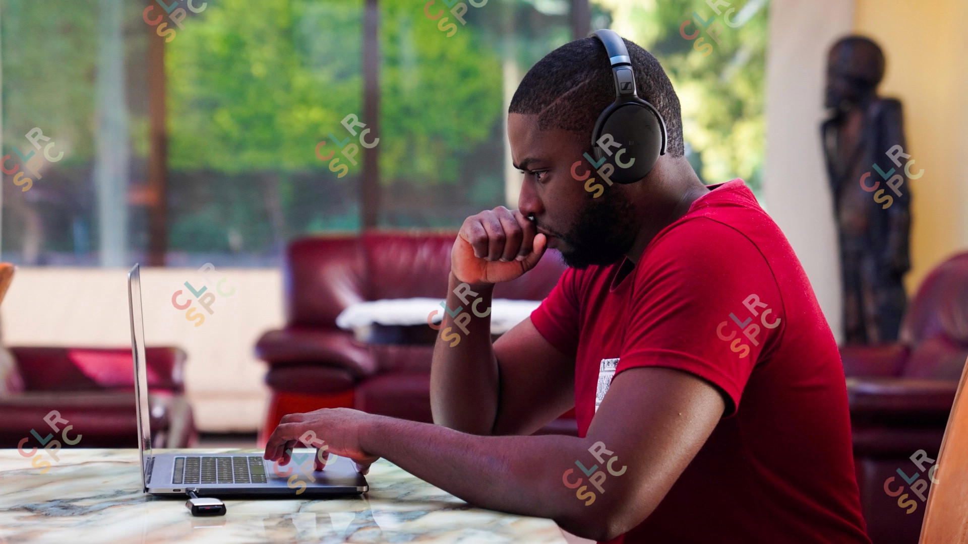 Black man working on laptop with headphones