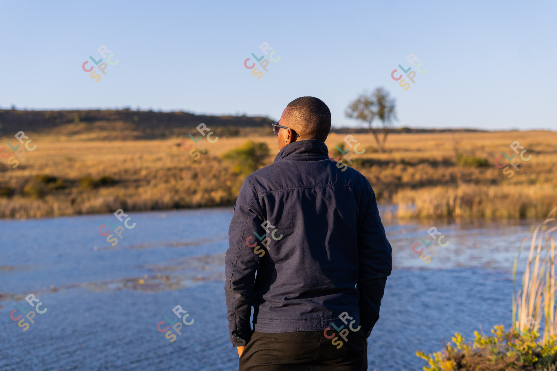 Black man overlooking a dam of water