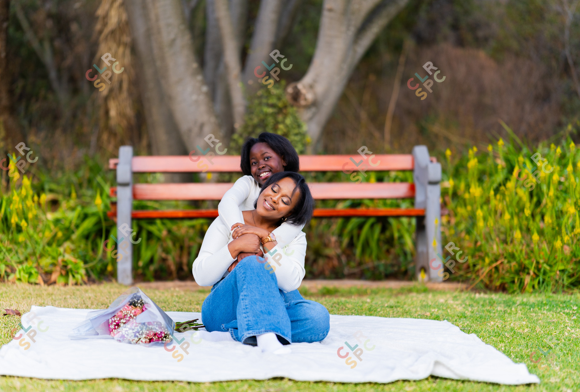 Happy mother and daughter hugging and smiling in a park outdoors.