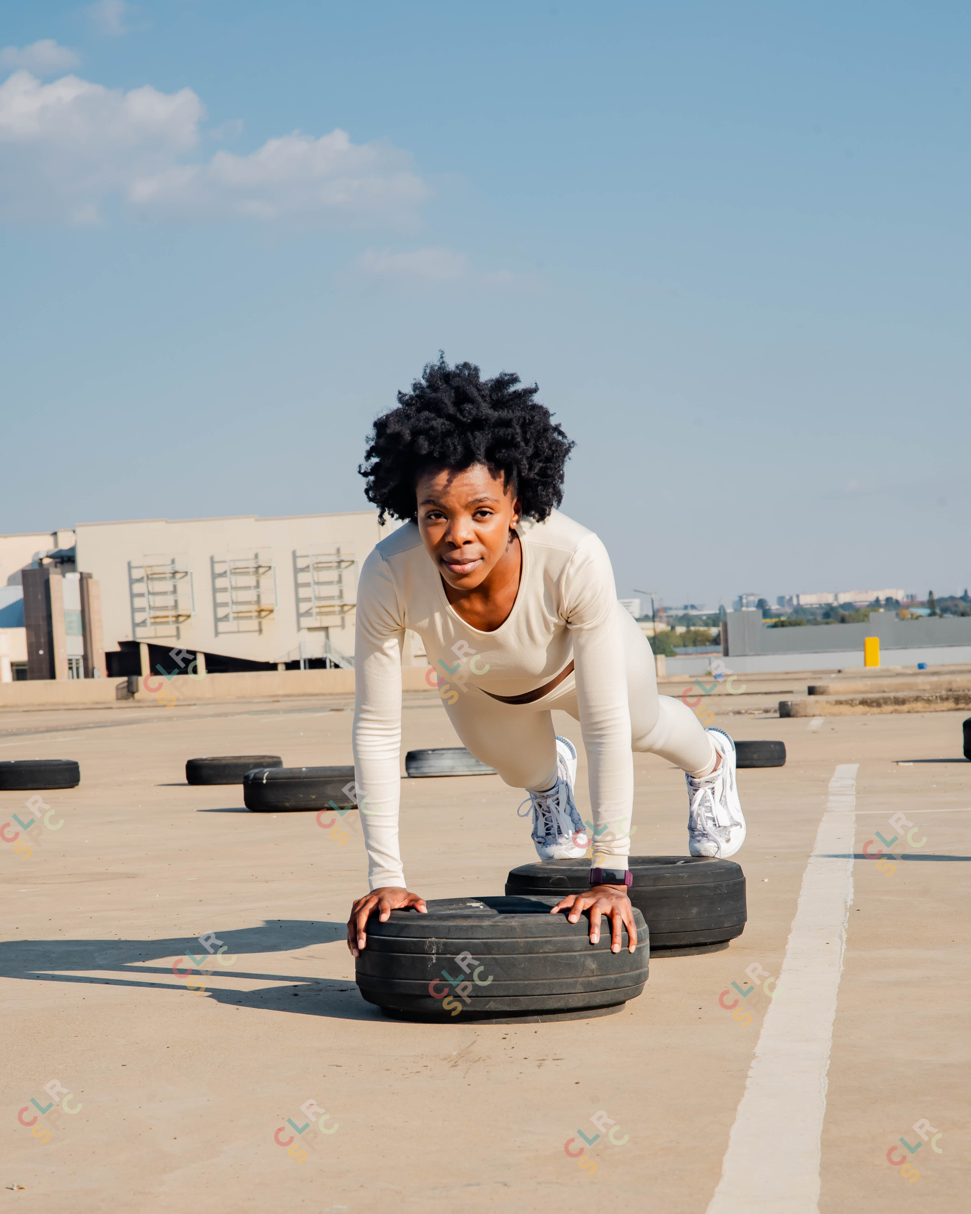 Black woman doing push-ups on a tyre